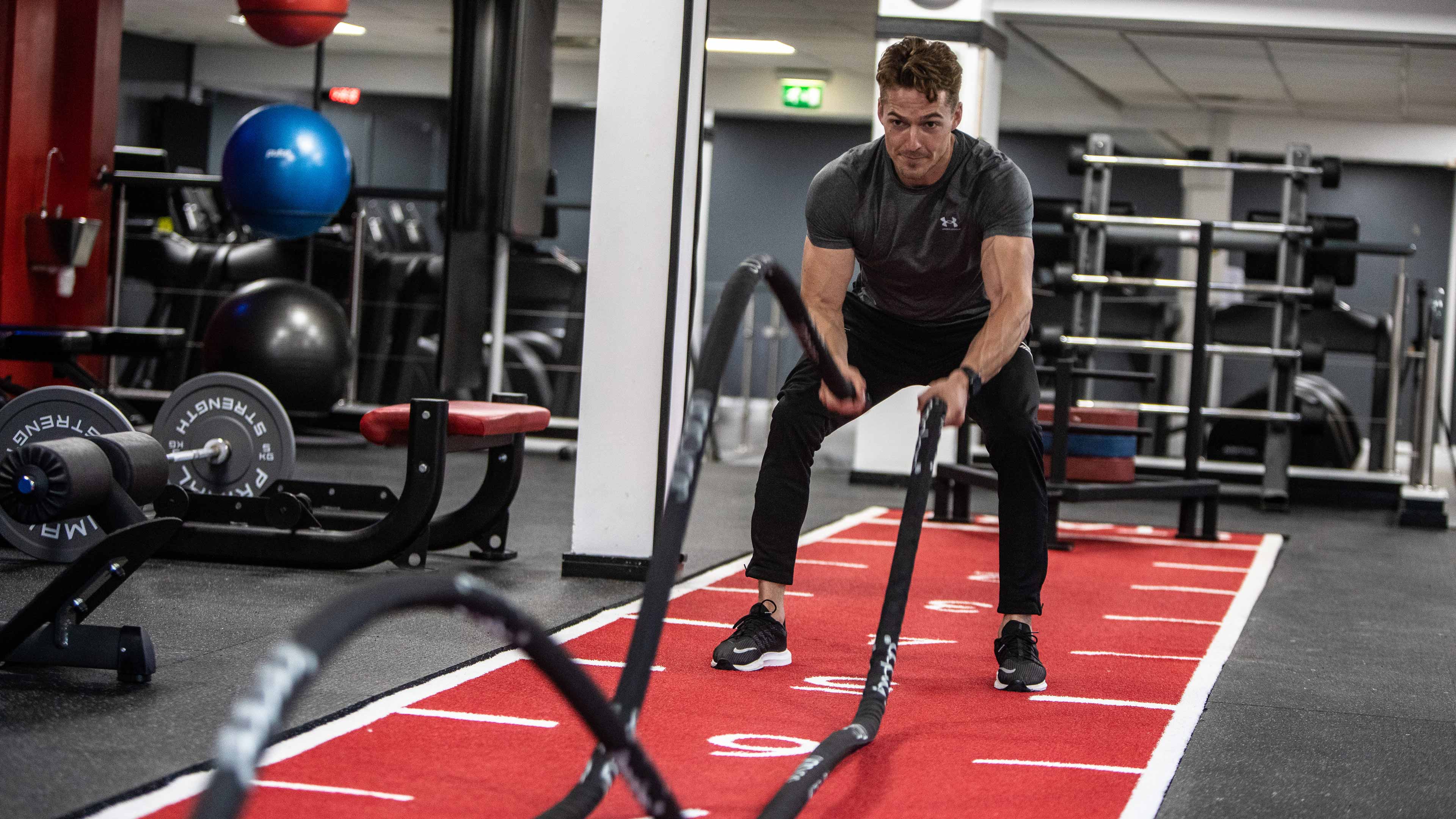 a man focused, using the battle rope